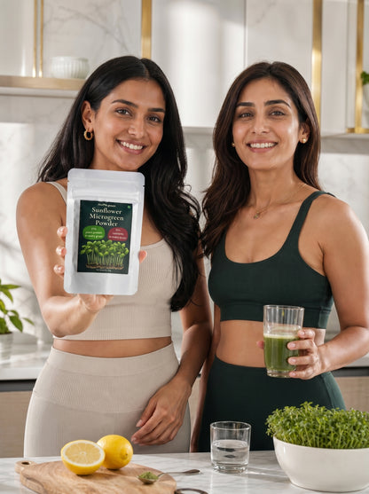 Two women in a kitchen holding a package of sunflower microgreen powder and a glass of green juice.